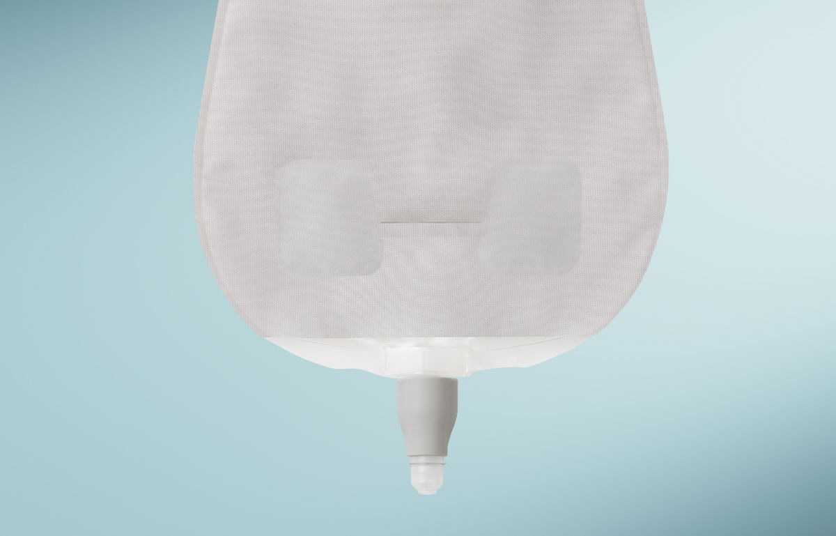 Poche d'urostomie SenSura Mio avec nouveau robinet rotatif sur fond bleu